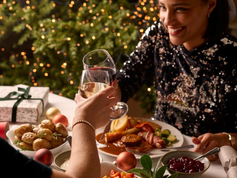 A woman in a glitzy sequined dress is at a Christmas dinner party.