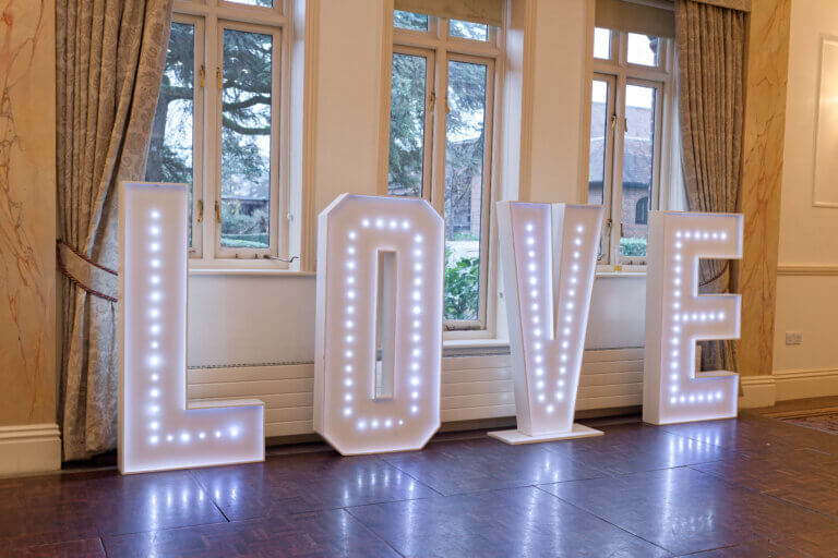 Light up sign spelling LOVE on the dance floor