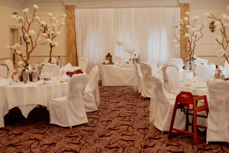 The Cedar Suite set for wedding breakfast with white table linen and florals.