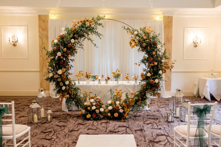 Close up of floral moon arch in front of the registrars table