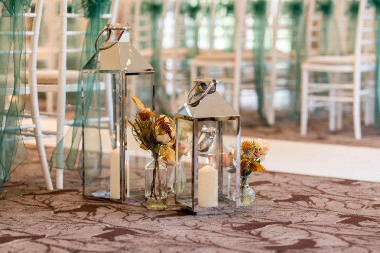 Storm lantern and floral arrangement at the foot of the chairs