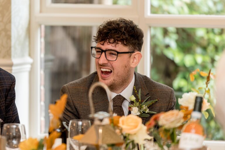 Groom smiles and laughs during the speeches